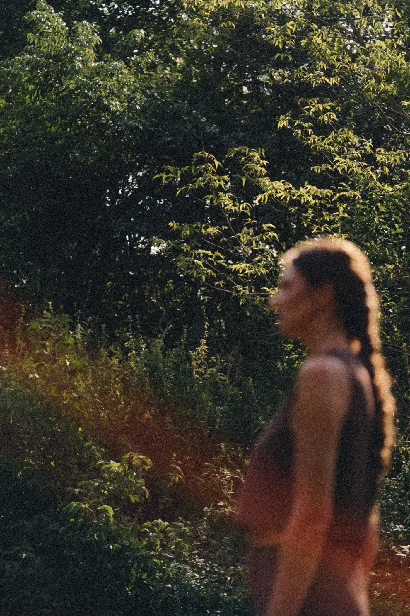 Kobieta z warkoczem stojąca pośród bujnej zieleni, jedność z naturą i filozofia slow beauty Tierra Natural