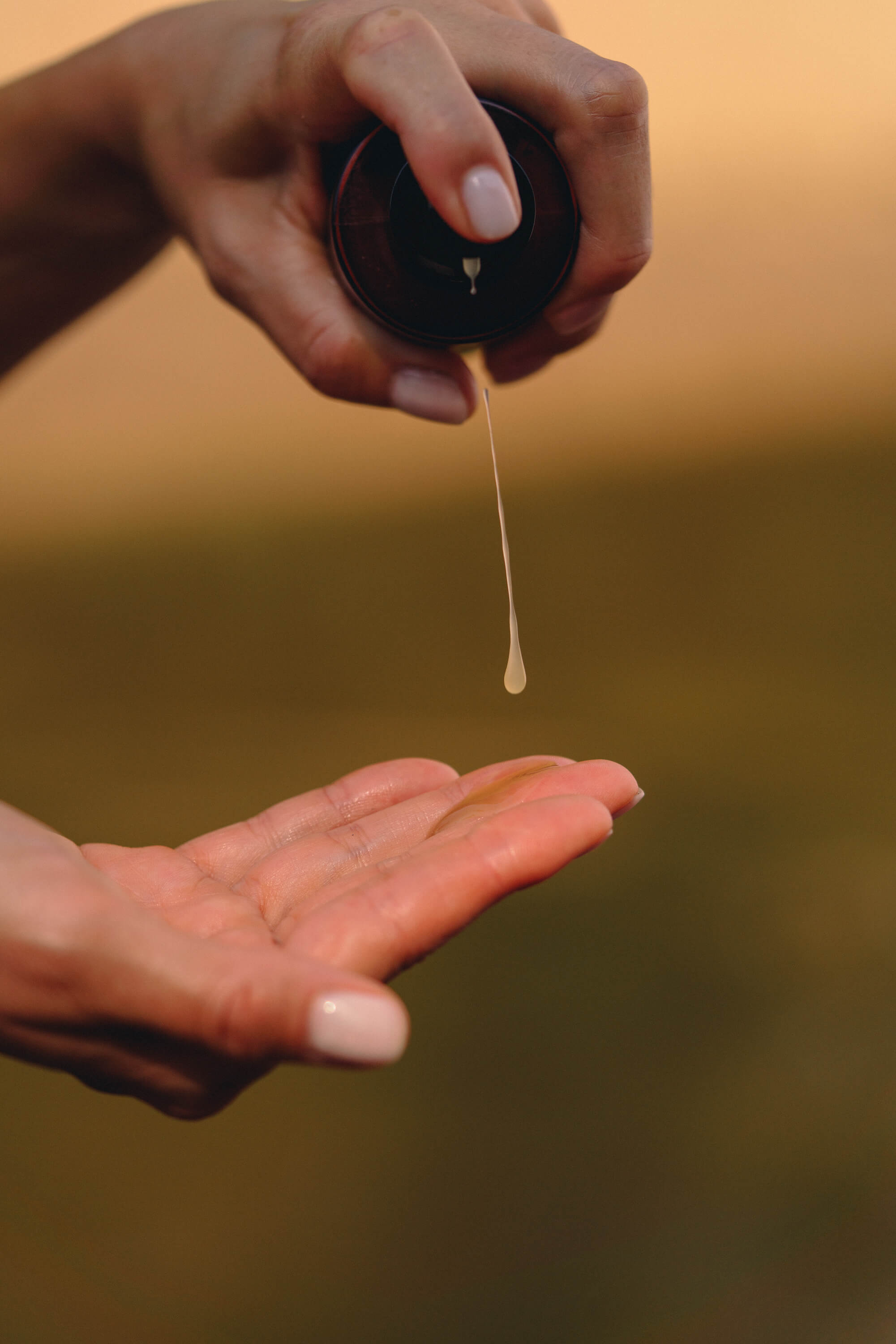 Konsystencja i piękny aromat kosmetyków Tierra Natural - kropla serum na ręce kobiety.
