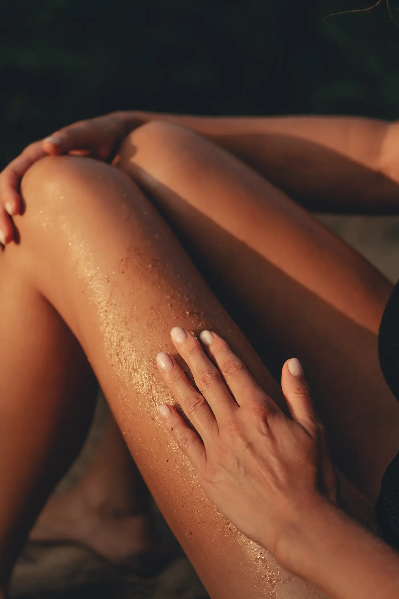Kobieta wcierająca naturalny kosmetyk Tierra Natural w skórę nóg - peeling z bogatym składem przebadany dermatologicznie.