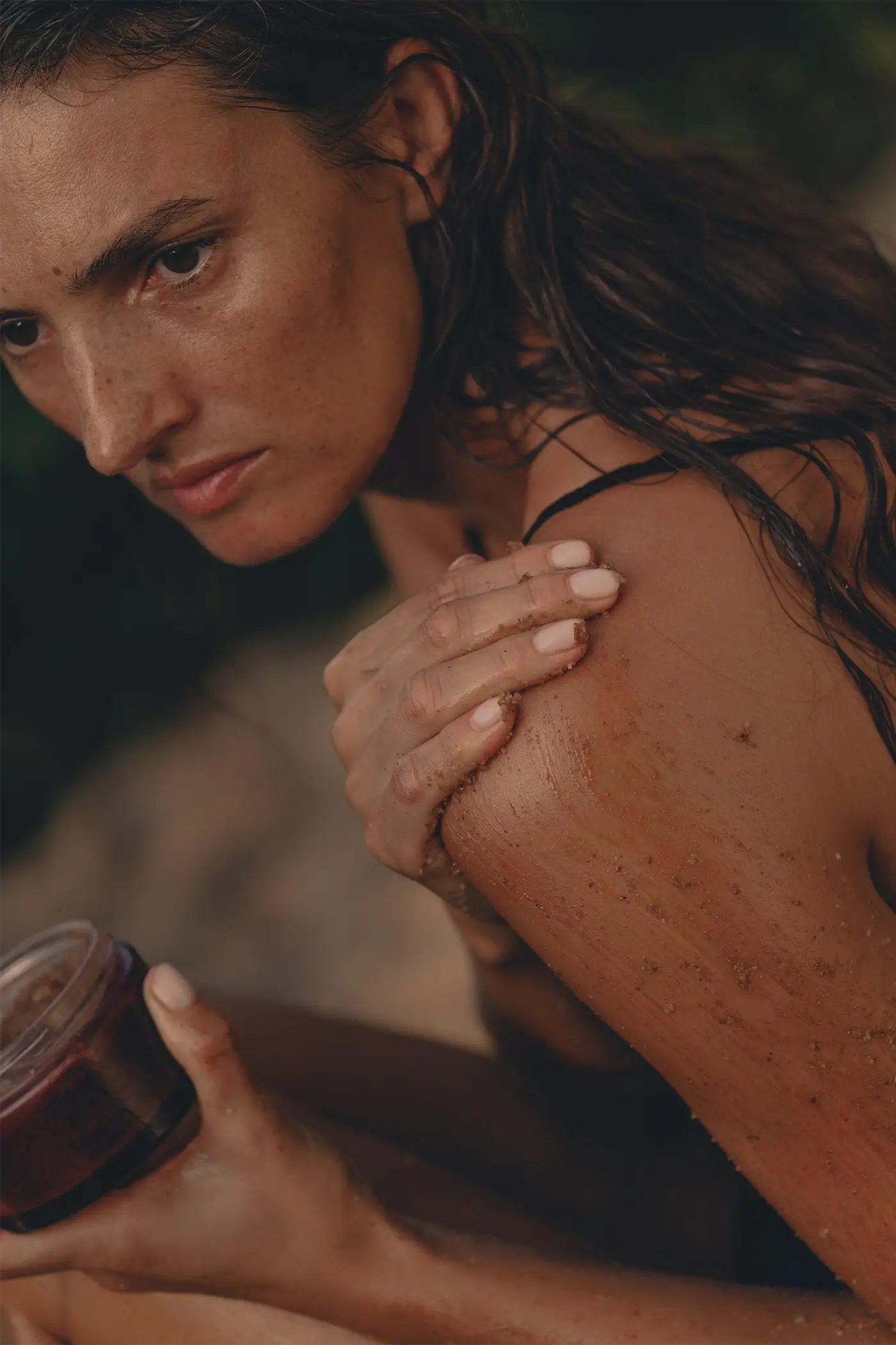 Kobieta wcierająca naturalny peeling Tierra Natural Body Scrub w skórę ciała.